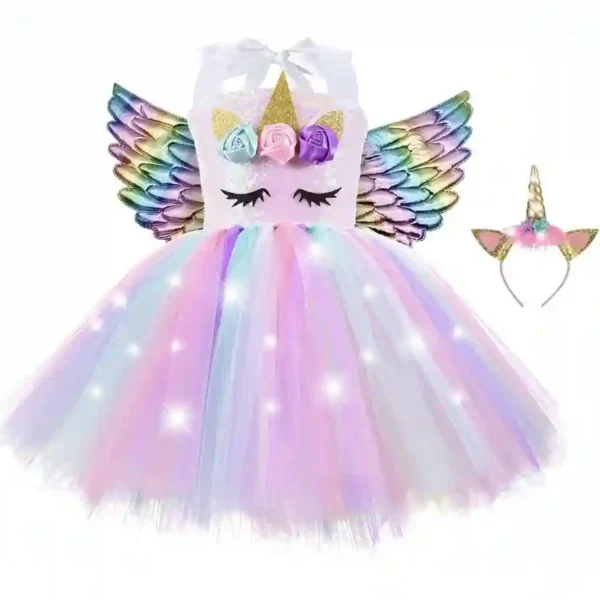 Robe de princesse licorne rose pastel avec jupe en tulle lumineuse à LED, ailes argentées et serre-tête fleuri. Une version douce et féerique pour anniversaire.